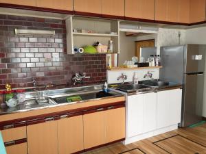 a kitchen with a sink and a refrigerator at HISAYO'S INN in Tokyo