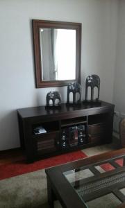 un centro di intrattenimento nero con uno specchio e due sedie di Arriendo Departamento a La Serena