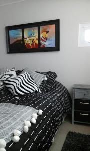 una camera da letto con un letto e due quadri sul muro di Arriendo Departamento a La Serena