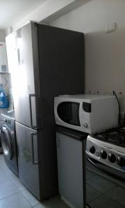 una cucina con un forno a microonde sopra un frigorifero di Arriendo Departamento a La Serena Altre 5 foto
