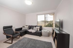 a living room with a couch and a television at Alpine Drovers Rest 20 Iron Pot Creek in Jindabyne