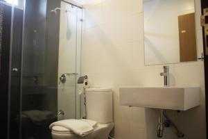 a bathroom with a toilet, sink, and shower stall at Fuller Hotel in Alor Setar
