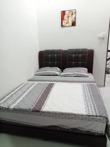 a bed in a room with a black bed frame at Amanda Homestay Dungun 1 in Dungun