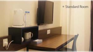 a desk with a tv and a monitor on top of it at Fuller Hotel in Alor Setar