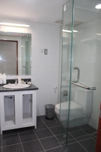 a bathroom with a glass shower and a sink at Myanmar Life Hotel in Yangon