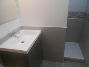 uma casa de banho branca com um lavatório e um chuveiro em Appartement 4p luchon cures & ski Soda em Luchon