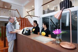 ein Mann steht an einer Theke in einem Geschäft in der Unterkunft Ratchadamnoen Residence in Bangkok