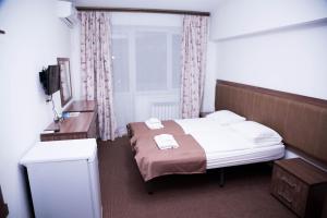 a small bedroom with a bed and a window at Academic Apartments in Almaty +32 photos