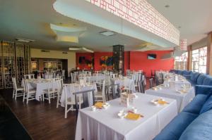 een eetkamer met witte tafels en stoelen bij The Sunan Hotel Solo in Solo