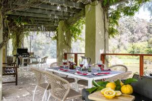 uma mesa com copos de vinho e frutas num pátio em Grand Mercure Basildene Manor em Margaret River