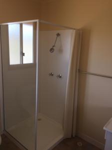 a shower with a glass door in a bathroom at Rangemore Estate in Maclagan