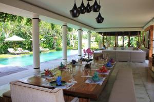 comedor con mesa y piscina en Villa Sally, en Canggu