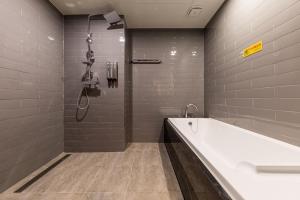a bathroom with a bath tub and a shower at Anyang Boutique Hotel AMA in Anyang