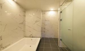 a white bathroom with a tub and a shower at Anyang Boutique Hotel AMA in Anyang