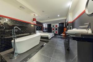 a bathroom with a tub and a bedroom with two beds at Anyang Boutique Hotel AMA in Anyang