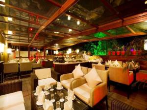 钱德加尔芬昌迪加尔酒店的有沙发、桌子和酒吧的餐厅