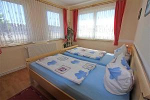 1 Schlafzimmer mit 2 Betten und 2 Fenstern in der Unterkunft Ferienhaus Ribnitz MOST 751 in Ribnitz-Damgarten