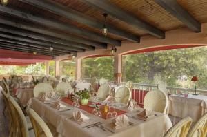 un comedor con mesas y sillas blancas en Hotel Stella Marina, en Serriera