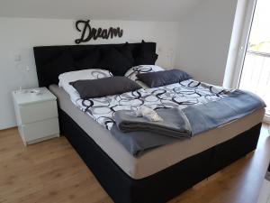 ein Bett in einem Schlafzimmer mit einem Schild an der Wand in der Unterkunft Haus am Hang; Ferienwohnung Fernblick in Stolberg
