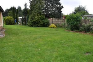 ツィノヴィッツにあるFerienhaus Zinnowitz USE 921の塀と緑の芝生のある庭