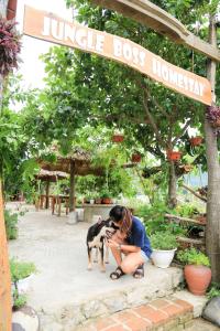 une femme caresse un chien dans un jardin dans l'établissement Jungle Boss Homestay, à Phong Nha