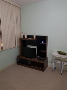 a living room with a tv and a table at Apartamento Santa Clara 86 in Rio de Janeiro