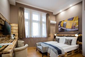 ein Schlafzimmer mit einem Bett und einem Schreibtisch in einem Zimmer in der Unterkunft Hotel Carpe Diem in Siófok