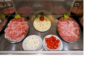a kitchen counter filled with lots of different types of food at Mercure Parma Stendhal in Parma