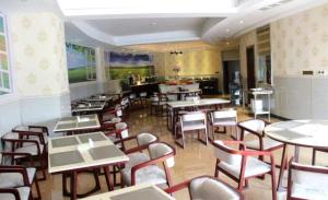 Hendra Hotel في ونزهو: غرفة طعام مع طاولات وكراسي في مطعم