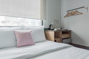 a bed with a pink pillow on top of it at Bunk & Bilik Hotel Jalan Ipoh in Kuala Lumpur