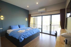 a bedroom with a blue bed with flowers on it at Ma der bua hotel in Udon Thani