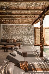 a room with several beds and a stone wall at OKU Kos in Marmari
