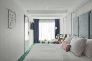 a bedroom with a large bed and a living room at Bunk & Bilik Hotel Jalan Ipoh in Kuala Lumpur