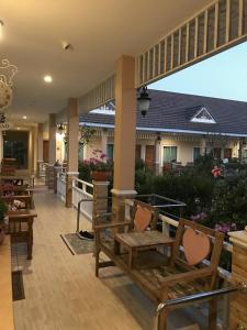 een patio met banken en tafels en een gebouw bij Suksopha Resort in Prachuap Khiri Khan