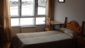 a bedroom with a bed in front of a window at Pension Santa Rita in Santiago de Compostela