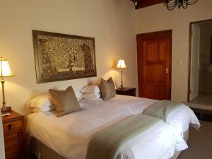a bedroom with a large white bed with two pillows at Uniondale Manor Guesthouse in Uniondale
