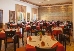 a restaurant with tables and chairs with red tablecloths at Sahara Douz in Douz