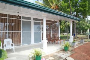 a screened in porch with chairs and tables at Serene Beach Hotel in Dickwella