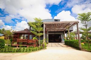 a house with a pergola in a garden at Ma der bua hotel in Udon Thani