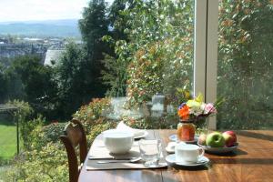 a table with a bowl of fruit and flowers on it at Bank House B and B in Penrith