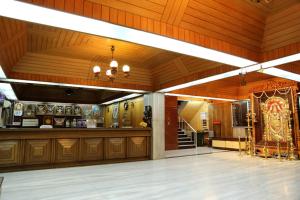 a large room with wood paneled walls and a large room with at Hotel Srilakshmi in Coimbatore