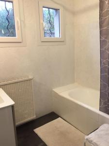 a white bathroom with a tub and a window at B&B Le Niaouli in Lorgues