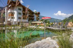 a resort with a pool of water in front of a building at Hotel Eder in Ramsau im Zillertal