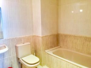 a bathroom with a toilet and a bath tub at Apartamentos Arcos Duplex Águilas in Águilas