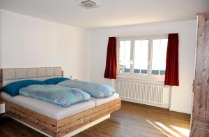 シュクオルにあるMinchületta 3のベッドルーム1室(ベッド1台付)、赤いカーテン付きの窓が備わります。