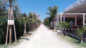 un camino de tierra junto a un edificio sin señal de estacionamiento en Campeggio Praia Mare, en Campofelice di Roccella