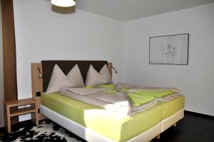 a bedroom with a bed with green and white at La Perla A1 in Scuol