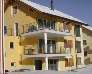 a yellow building with balconies on the side of it at Crastuoglia 855-1 in Scuol