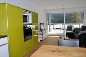 sala de estar con pared verde y sala de estar con sofá en La Perla A2, en Scuol