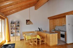 a kitchen with a table and chairs in a room at Pütvia E6 in Scuol